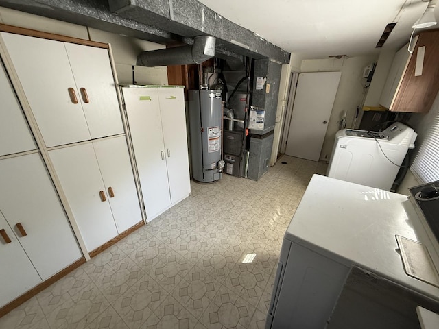 interior space with cabinet space, light floors, water heater, and washer and clothes dryer