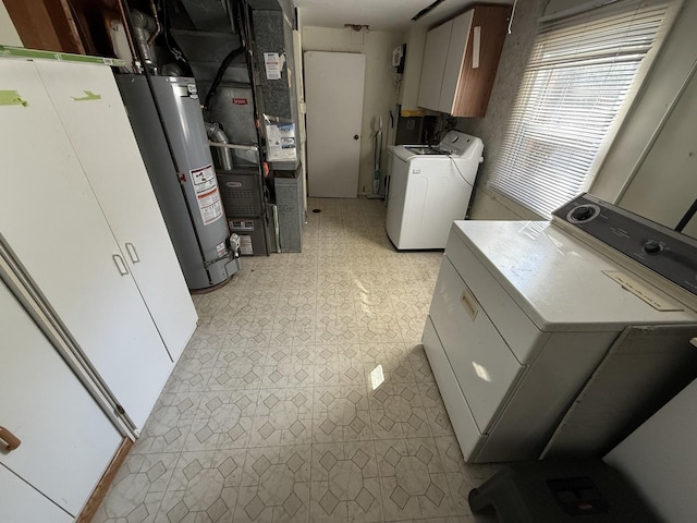 laundry room with gas water heater, cabinet space, independent washer and dryer, and light floors