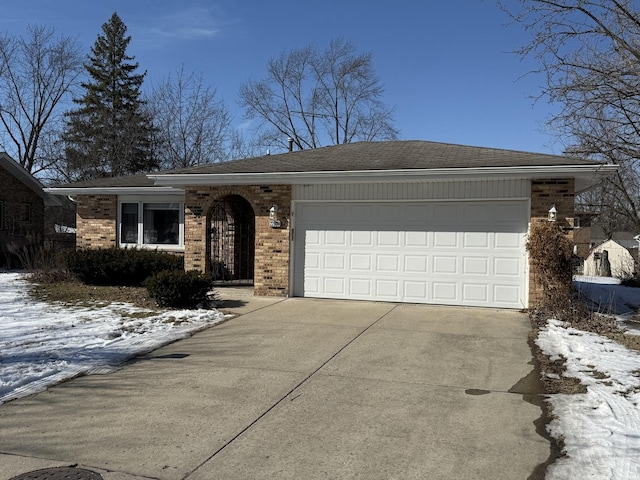 single story home with brick siding, concrete driveway, a garage, and roof with shingles