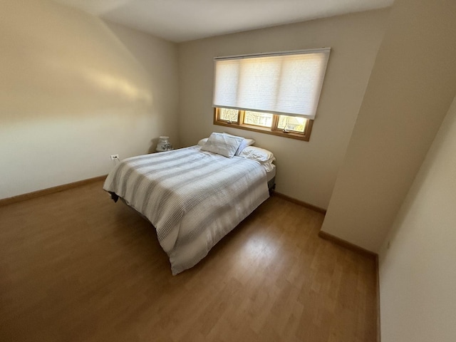 bedroom featuring baseboards and light wood finished floors