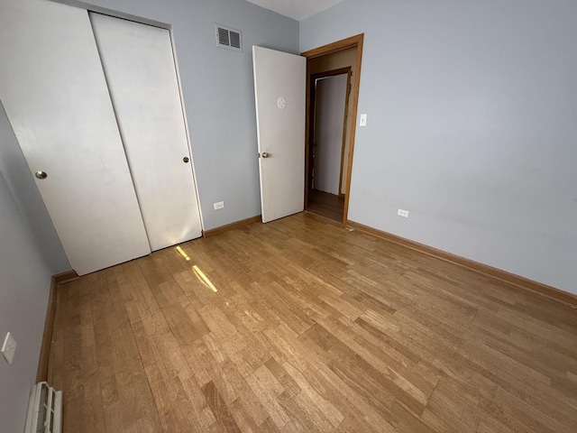 unfurnished bedroom with baseboards, visible vents, and light wood finished floors