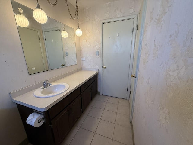 bathroom featuring tile patterned floors, wallpapered walls, and vanity