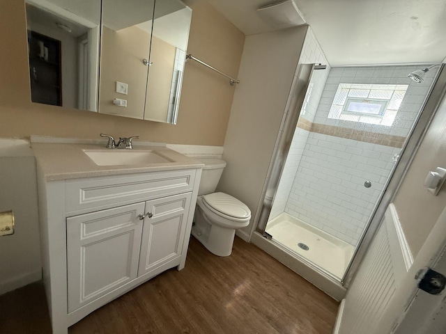 full bath with vanity, toilet, wood finished floors, and a stall shower