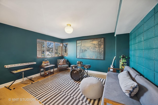 interior space featuring an accent wall, wood finished floors, and baseboards