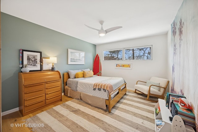 bedroom with a ceiling fan, wood finished floors, and baseboards