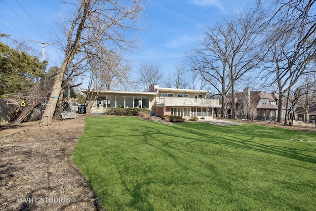 back of house featuring a chimney and a yard