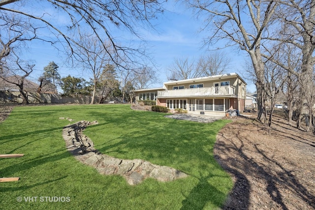 rear view of house with a yard and a sunroom