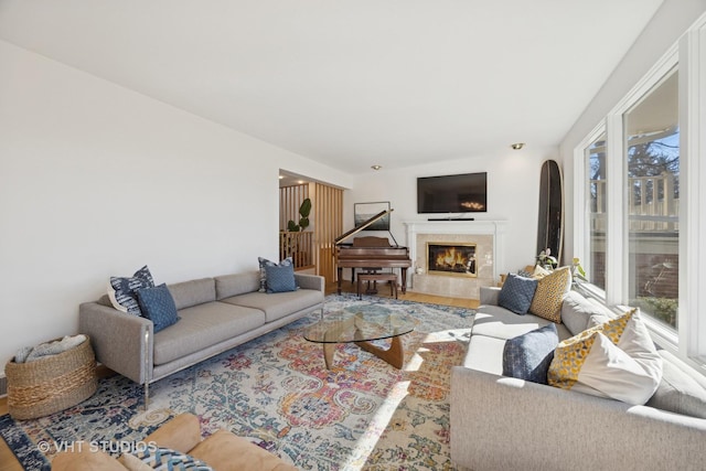 living room with arched walkways, wood finished floors, and a premium fireplace