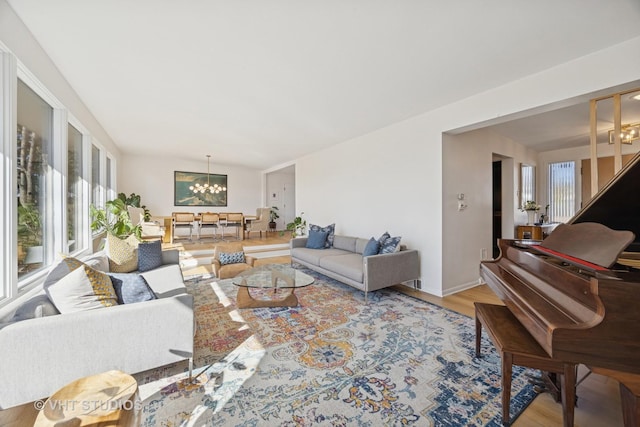 living room with a notable chandelier, wood finished floors, and baseboards