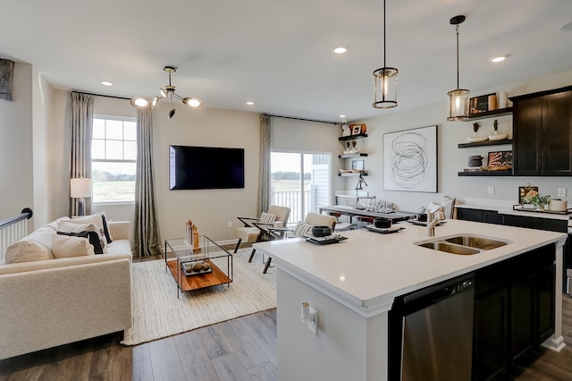 kitchen featuring dark wood finished floors, light countertops, stainless steel dishwasher, open shelves, and a sink