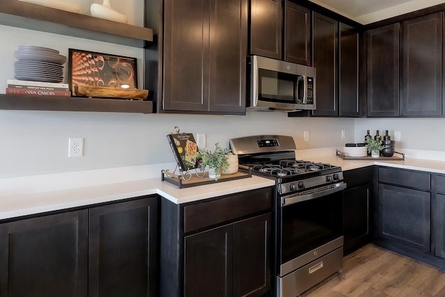 kitchen with stainless steel appliances, wood finished floors, light countertops, and open shelves