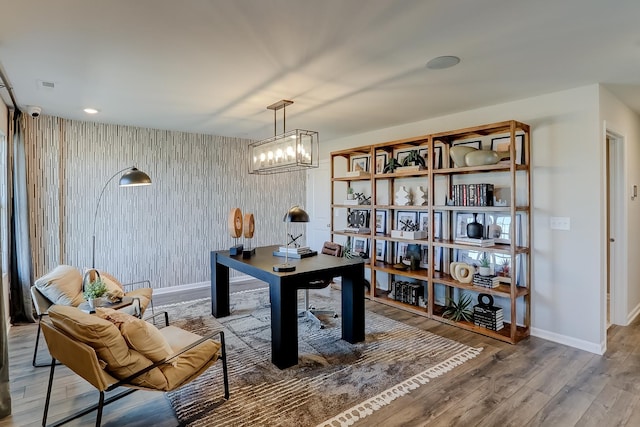 office space with an inviting chandelier, baseboards, and wood finished floors