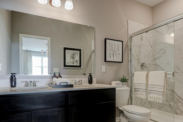 bathroom with a sink, a shower stall, toilet, and double vanity