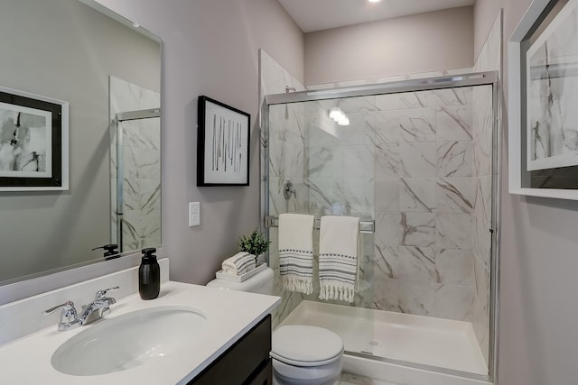 full bathroom with vanity, a shower stall, and toilet