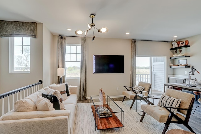 living area featuring a chandelier, recessed lighting, baseboards, and wood finished floors