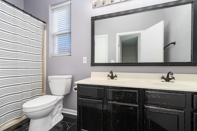 full bathroom with double vanity, toilet, and a sink