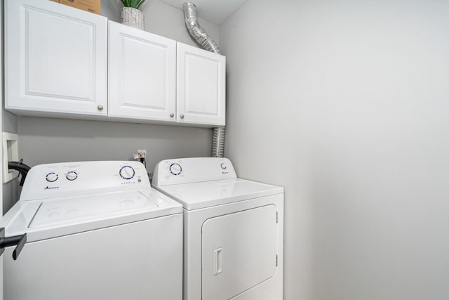 clothes washing area with cabinet space and independent washer and dryer