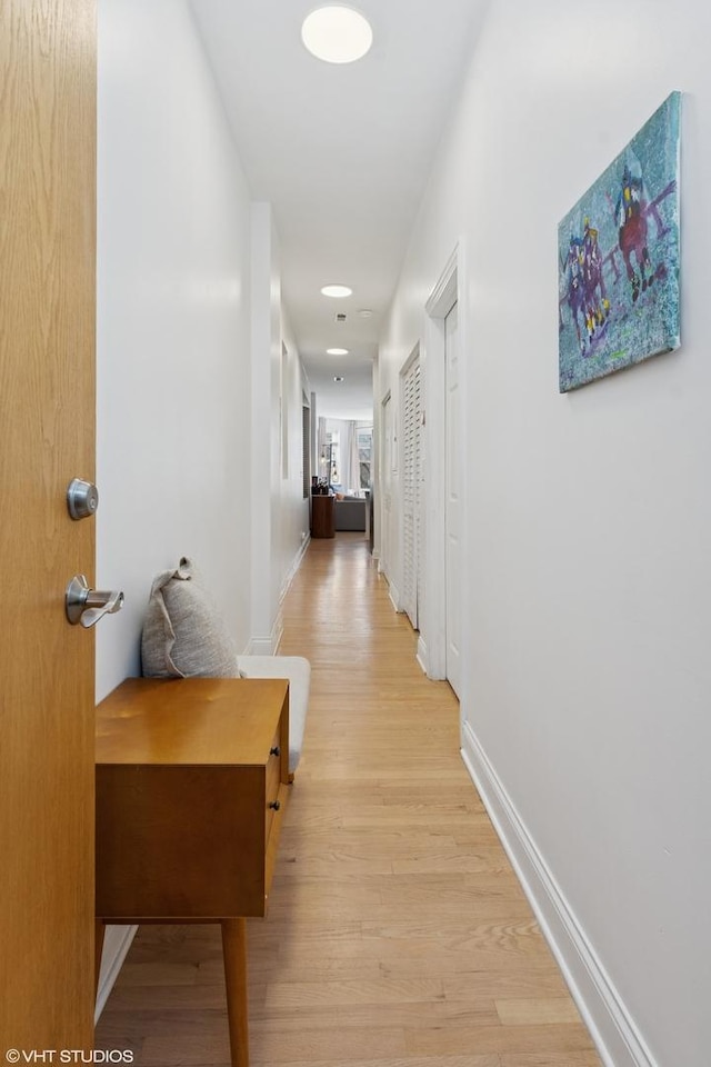 hall featuring recessed lighting, baseboards, and light wood-type flooring