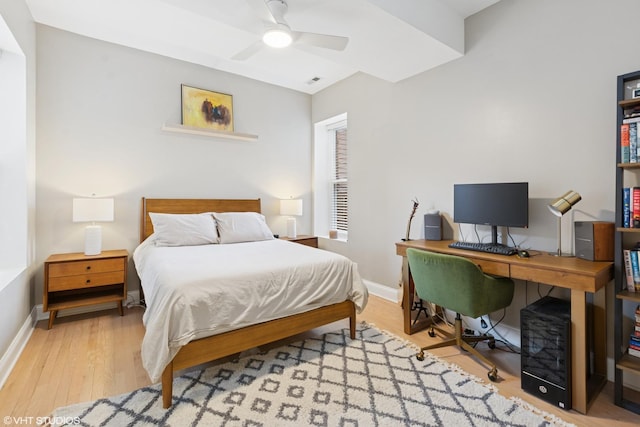 bedroom featuring a ceiling fan, visible vents, wood finished floors, and baseboards