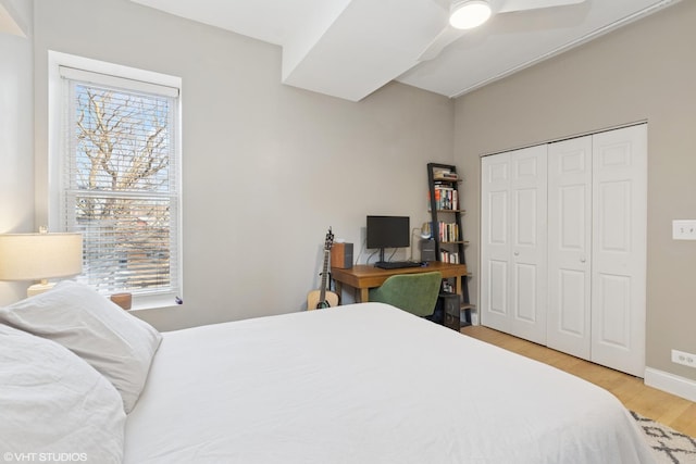 bedroom with multiple windows, a ceiling fan, light wood-type flooring, and a closet