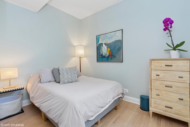 bedroom featuring light wood finished floors and baseboards