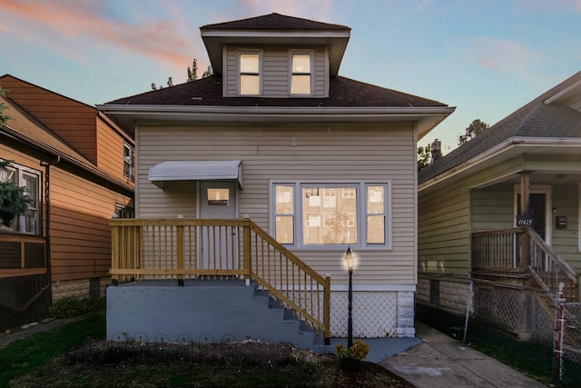 rear view of house with a shingled roof