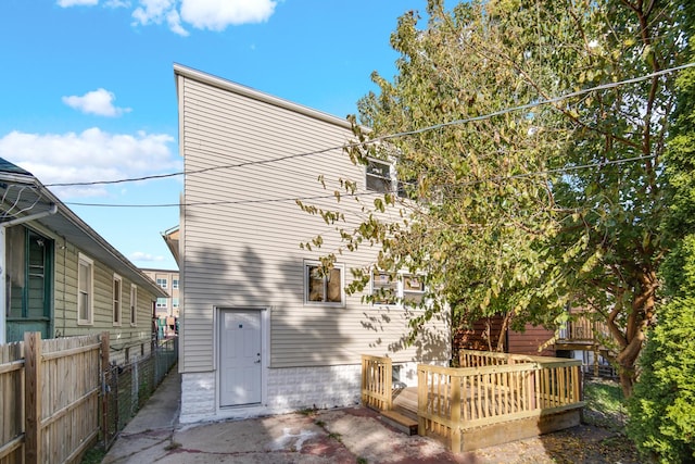 back of property featuring fence and a wooden deck