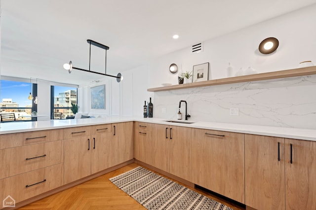 kitchen featuring a sink, open shelves, light brown cabinetry, and light countertops