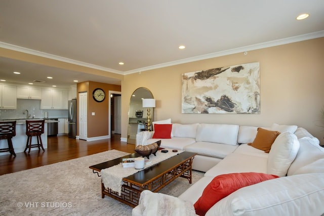 living area featuring recessed lighting, crown molding, and dark wood-type flooring