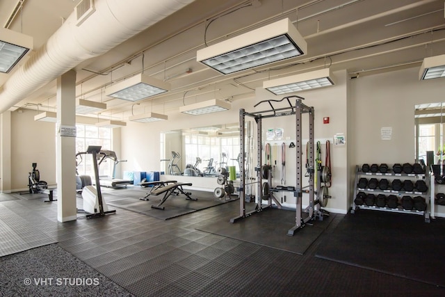 exercise room with baseboards and plenty of natural light