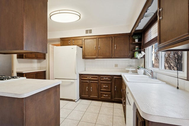 kitchen with white appliances, visible vents, open shelves, a sink, and light countertops