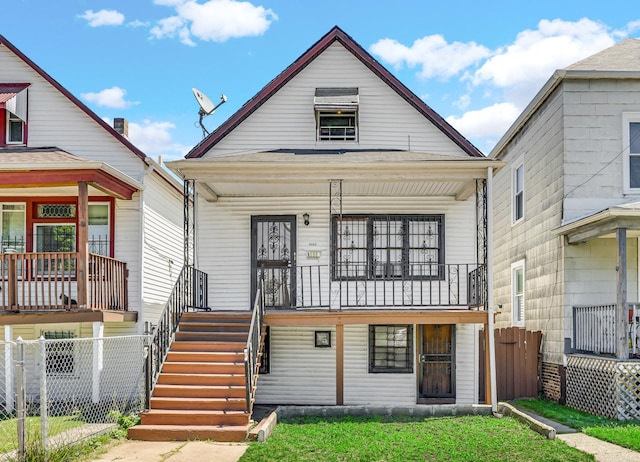 view of front of property featuring covered porch, fence, and stairway