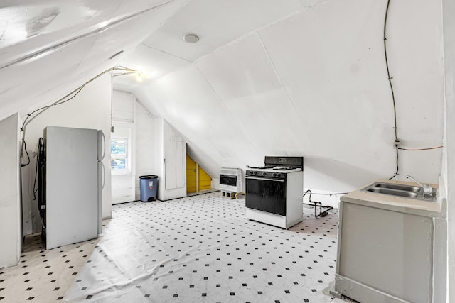 bonus room featuring heating unit, vaulted ceiling, and a sink