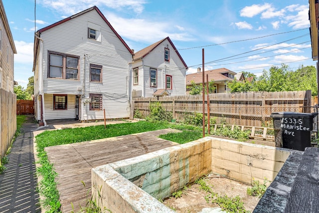 rear view of house featuring a fenced backyard