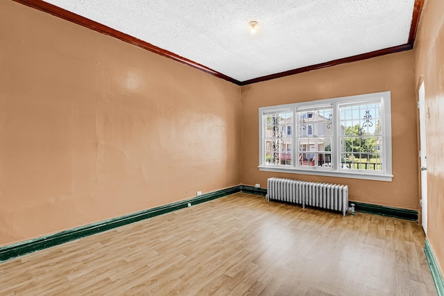 unfurnished room with baseboards, radiator, wood finished floors, a textured ceiling, and crown molding