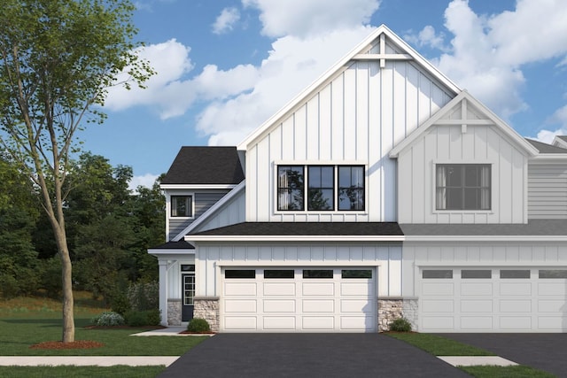 view of front facade with board and batten siding, stone siding, a garage, and aphalt driveway