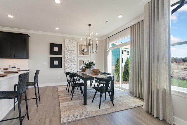 dining space featuring a chandelier, visible vents, baseboards, ornamental molding, and light wood-type flooring