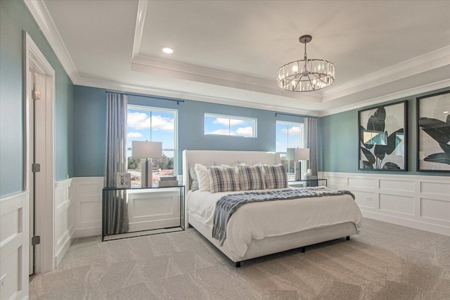 bedroom with ornamental molding, a raised ceiling, carpet flooring, and a decorative wall