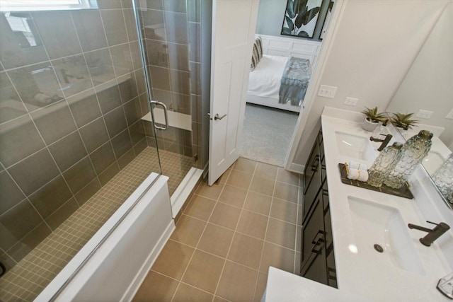 full bath featuring double vanity, a stall shower, tile patterned flooring, and ensuite bathroom