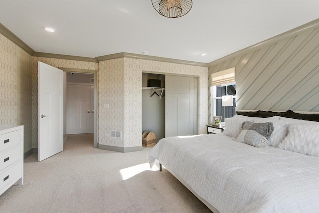 carpeted bedroom with ornamental molding, a closet, and wallpapered walls