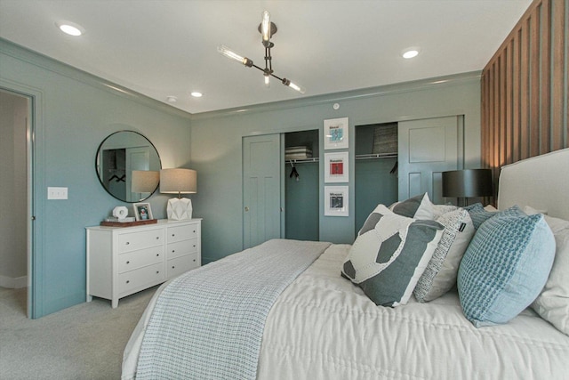 carpeted bedroom featuring recessed lighting and two closets