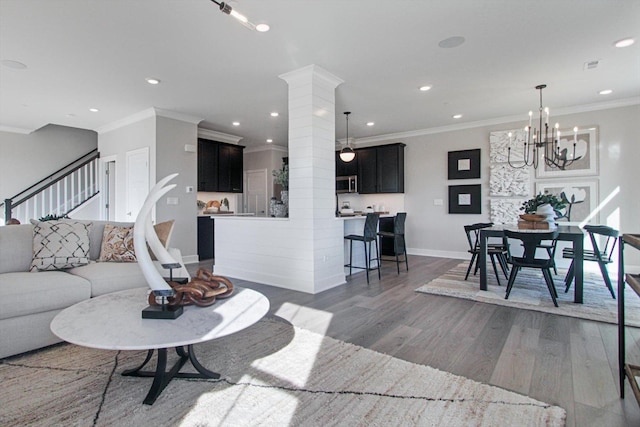 living room with recessed lighting, wood finished floors, baseboards, stairway, and crown molding