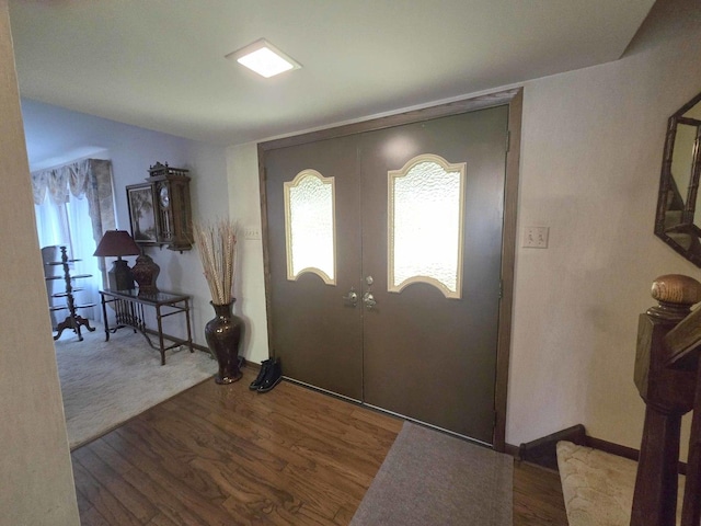 foyer featuring french doors, baseboards, wood finished floors, and stairway