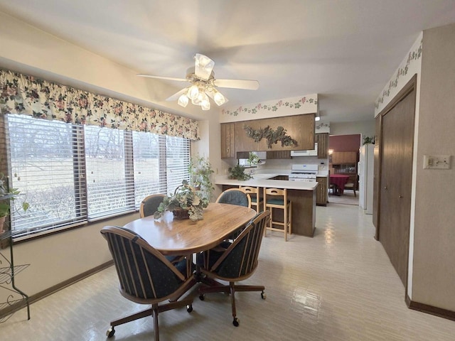 dining room featuring a ceiling fan and baseboards