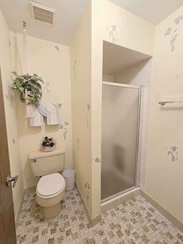 bathroom featuring toilet, baseboards, visible vents, and a stall shower