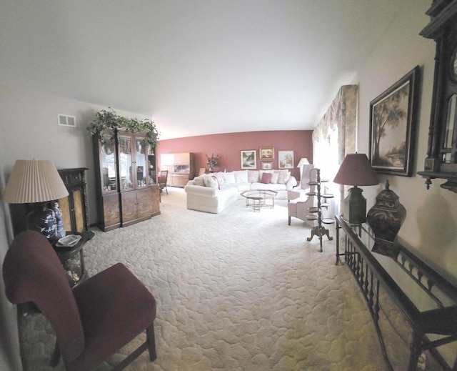 living room featuring visible vents, lofted ceiling, and carpet floors