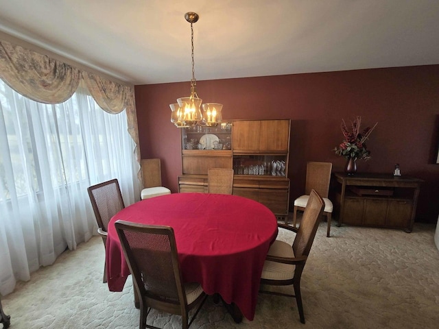 dining area with light carpet and a notable chandelier