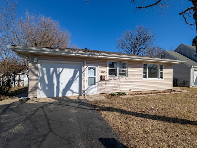 ranch-style house featuring a garage and aphalt driveway