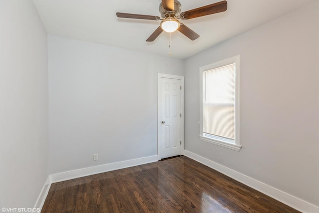 unfurnished room featuring dark wood finished floors, ceiling fan, and baseboards