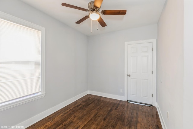 spare room with a ceiling fan, baseboards, and dark wood-style flooring